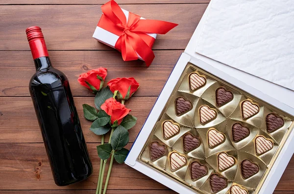 Valentines day. valentine sweet chocolate and red wine on wooden background