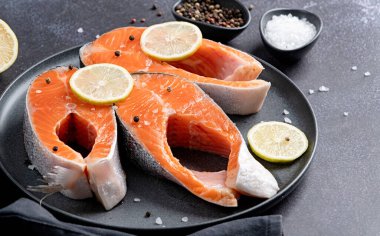 Koyu arkaplanda limonlu ve baharatlı balık alabalığı kopyala