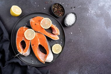 Koyu arkaplanda limonlu ve baharatlı balık alabalığı kopyala