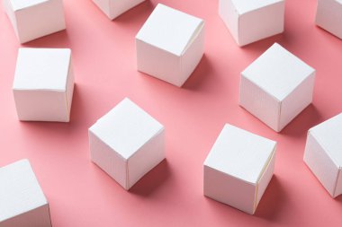 Açık pembe duvarın üzerindeki tahta masanın üzerinde boş beyaz blok küpleri, iş iletişimi konsepti