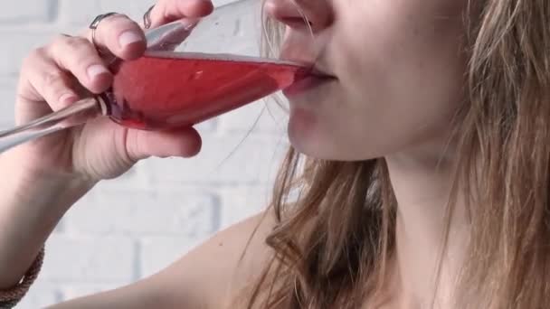 アルコール飲料コンセプト カクテルドレスの女性のクローズドレス グラスからローズシャンパン 白レンガの壁の背景 — ストック動画