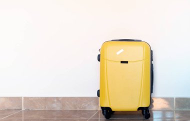 Otel odasının arka planında sarı bavullar.