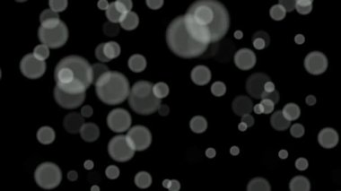 Siyah arkaplan üzerinde beyaz daireler bokeh parçacıkları soyut arkaplan döngüsü.