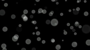 Siyah arkaplan üzerinde beyaz daireler bokeh parçacıkları soyut arkaplan döngüsü.