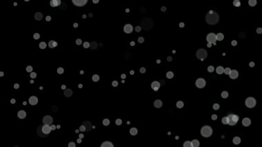 Siyah arkaplan üzerinde beyaz daireler bokeh parçacıkları soyut arkaplan döngüsü.