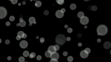 Siyah arkaplan üzerinde beyaz daireler bokeh parçacıkları soyut arkaplan döngüsü.
