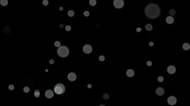 Siyah arkaplan üzerinde beyaz daireler bokeh parçacıkları soyut arkaplan döngüsü.