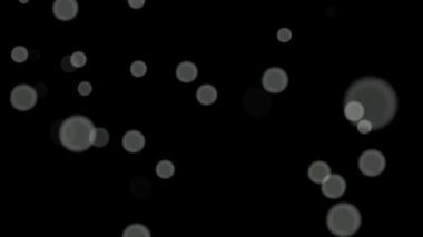 Siyah arkaplan üzerinde beyaz daireler bokeh parçacıkları soyut arkaplan döngüsü.