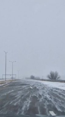 Kışın kar fırtınasında karlı bir otoyolda yol almak. Kış yolculuğu.