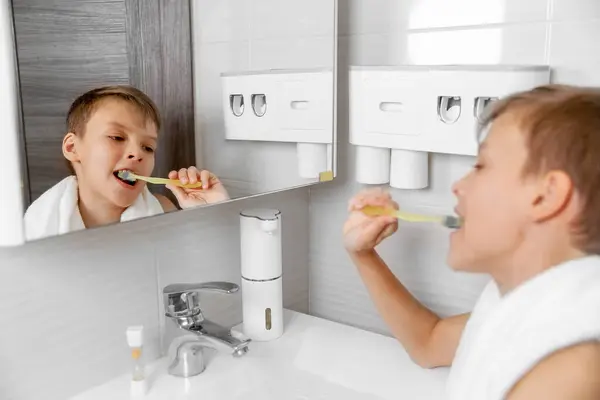 Teenage self-care: a refreshing moment in the bathroom, boy brushes his teeth