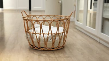 Wicker basket made of natural rattan woven with cushion inside. Selective focus with blurred dressing room decor background. Handmade storage rattan basket stylish interior item eco design. clipart