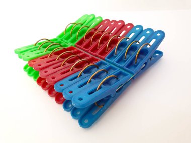 Beyaz arka planda izole edilmiş renkli plastik mandallar ya da elbise askıları. Mandallar plastikten yapılmış ve demir eklentisi var. Ev İşi ve Çamaşır İşleri Konsepti.