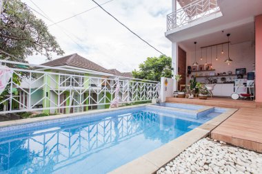 Modern bir tatil evinin arka bahçesinde yüzme havuzu. Yarı açık mutfak, minimalist modern İskandinav dekorasyonu. Evin dış tasarımı.