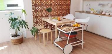 Ahşap mutfak tramvayı ile modern mutfak iç tasarımı. Yarı açık havada, İskandinav tasarım minimalist mutfak. Ahşap yemek masası, sandalye ve yeşil bitki..