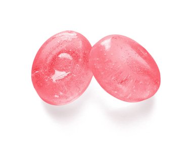 Beyaz arka planda izole edilmiş iki pembe şeker. Üst Manzara. Çilek aromalı kristal sert şeker dokuyu kapatır.