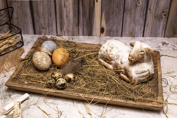 Easter lamb made of cake with colorful Easter eggs on straw, still life. More still lifes and Easter motifs in my collection