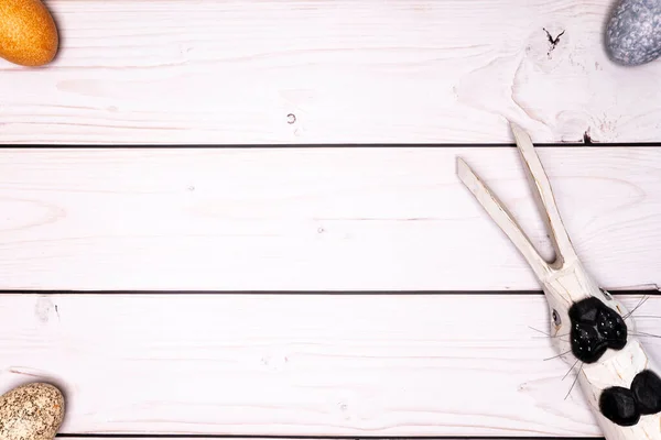 rustic, white wooden table top with subtly colored Easter eggs and wooden Easter bunny