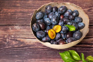 Taze toplanmış eriklerle dolu bir köy kasesi. Bir kesik..
