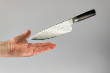Keskin mutfak bıçağı erkek elinin üzerine düşer. Kaza önleme