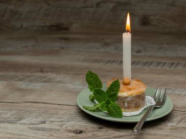 Nut doğum günü pastası, yanan mumla birlikte bir tabağa yerleştirilmiş nane filizi. Kopyalama alanı ile
