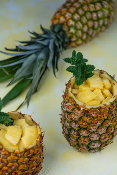 新鲜多汁的菠萝片放在两个空旷的菠萝水果中 背景是一个完整的菠萝果 — 图库照片