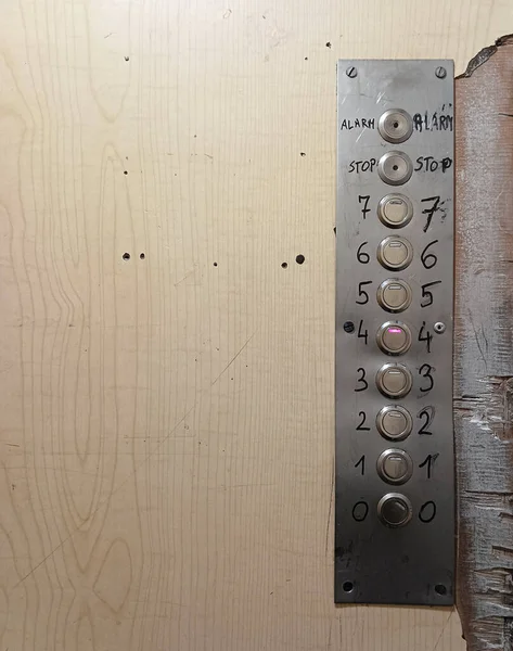 Old, dilapidated elevator cabin with metal buttons