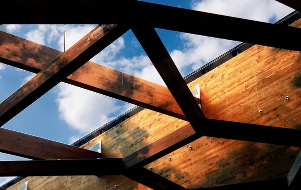 stock image Illuminated roof truss with tree shadows on wood