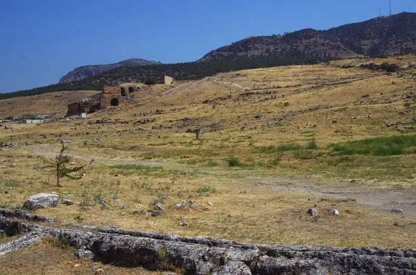 Hierapolis 'in bozkırları ve antik şehirden kalan elementler. Cokelez Dağı 'nın yamacındaki harabeler