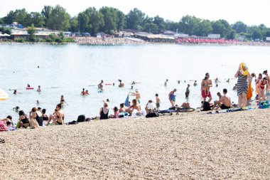 Kumsalda güneşlenirken insanlar