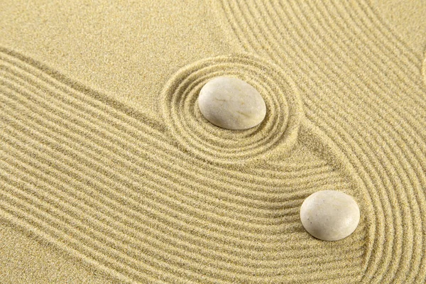 Zen garden with the stones on sand pattern