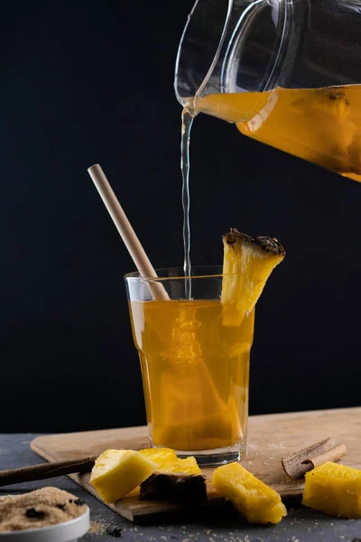 Ananas Tepache. Ferahlatıcı içecek, taze ananas kabuğu ve çekirdekten yapılan hafif mayalanmış içecek, artı kahverengi şeker. Yüksek kalite fotoğraf. Bardak mayalanmış içecekle doluyor.. 