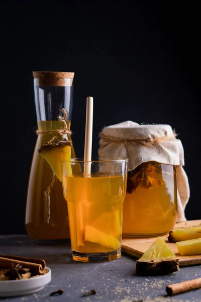 Ananas Tepache. Ferahlatıcı içecek, taze ananas kabuğu ve çekirdekten yapılan hafif mayalanmış içecek, artı kahverengi şekerleme mevsimi. Yüksek kaliteli fotoğraf. Koyu arkaplan.
