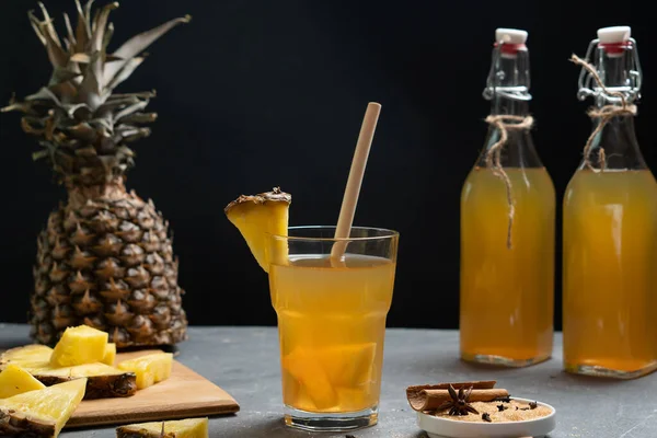 Ananas Tepache. Ferahlatıcı içecek, taze ananas kabuğu ve çekirdekten yapılan hafif mayalanmış içecek, artı kahverengi şeker. Yüksek kalite fotoğraf. Bardakta servis ediliyor. Alçakgönüllülük. Koyu arkaplan.