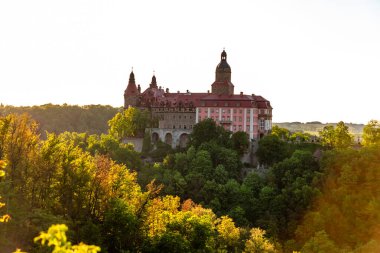 Baharda gün batımında Polonya 'da Ksiaz Kalesi ile vadi manzarası