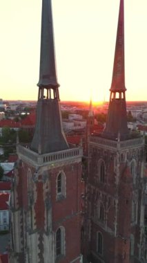 Polonya 'nın eski Wroclaw kasabasındaki kilisenin üzerindeki hava üssü gün batımında