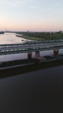 Yazın günbatımında Varşova 'da trenle köprüden geçen hava üssü.