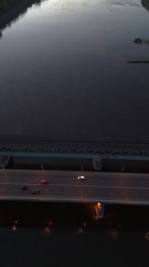 Varşova 'daki Vistula nehrinin üzerindeki hava görüntüsü ve gün batımında ulaşım.