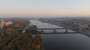 Vistula Nehri üzerinde sonbaharda Varşova üzerinde günbatımı manzaralı havadan üstgeçit.