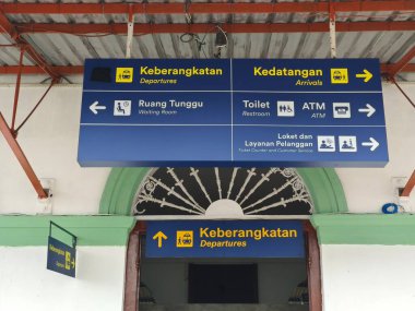 Kediri Doğu Java, Endonezya - 16 Mart 2025: İstasyondaki gezginler, dijital ekran olarak gerçek zamanlı tren tarifesi bilgilerini gösterirler.