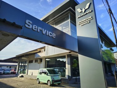Kediri, Endonezya-Haziran, 08 2025-Wuling Motors logosu galeride, Endonezya 'da yaygın bir Çin otomobil markası, Wuling araba satıcısının önü.