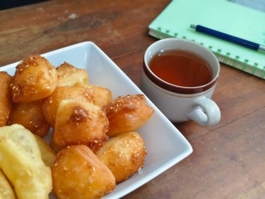 Bolang balyalama, Odading, küp ya da bloklarda kızarmış ekmek, açık kahverengi bir dış deri ve susam tohumları serpiştirilmiş, içi boş ve ahşap masa üzerinde bir fincan çay ile yumuşacık