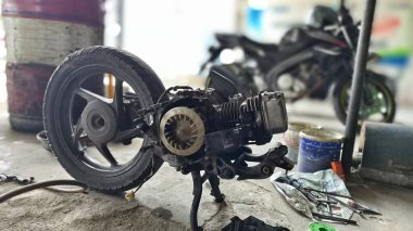 Tüm kaportası çıkarıldıktan sonra motorsiklet motoru tamir ediliyor. Parçaları birleştirmek için konutu sökmeden önce motosiklet tamir ediliyor.