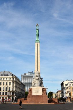 İkonik Özgürlük Anıtı, Letonya 'nın Riga kentinin tarihi mimarisi ile çevrili ince bulutlu parlak mavi bir gökyüzüne karşı dimdik ayakta duruyor. Bu merkezi simge Letonya bağımsızlığını ve ulusal gururu sembolize ediyor.