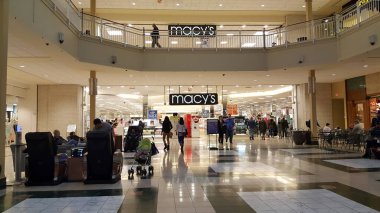 WHITEHALL, PENNSYLVANIA, US - March 23, 2019: Customers come and go at the entrance of Macy's Allentown PA at the Lehigh Valley Mall. clipart