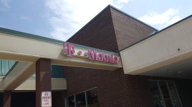 ALLENTOWN, PENNSYLVANIA, ABD - 19 Mayıs 2019: Bir T-Mobile mor logosu Village West alışveriş merkezindeki kablosuz sağlayıcının perakende satış yerini süslüyor. 