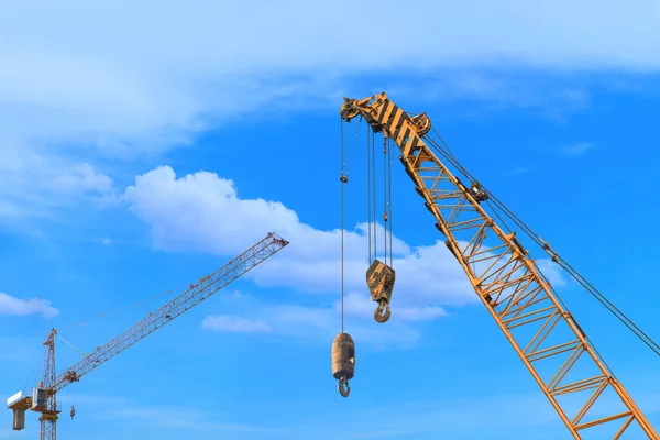 stock image Close-up industrial big crane with steel hook for work on construction building outdoor site on blue sky in daylight, copy space