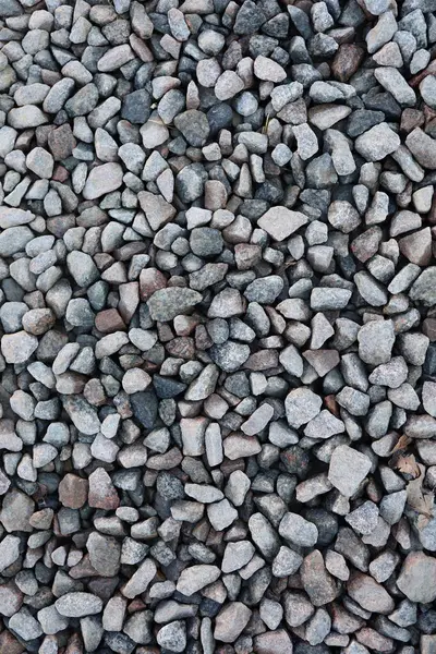 Çakıl ve kaldırım taşı dokusu. Ezilmiş taş, taş ve çakıldan yapılmış ev yapımı yollar. Ezilmiş taş ve taş dokusunun fotoğrafı.