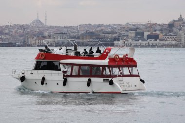 19-01-2024 İstanbul-Türkiye: Şehir Arkaplanlı Kırmızı ve Beyaz Tekne