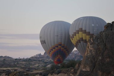 Açık mavi gökyüzünde yüzen iki renkli sıcak hava balonu