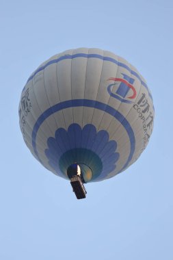 Açık mavi gökyüzünde yüzen iki renkli sıcak hava balonu